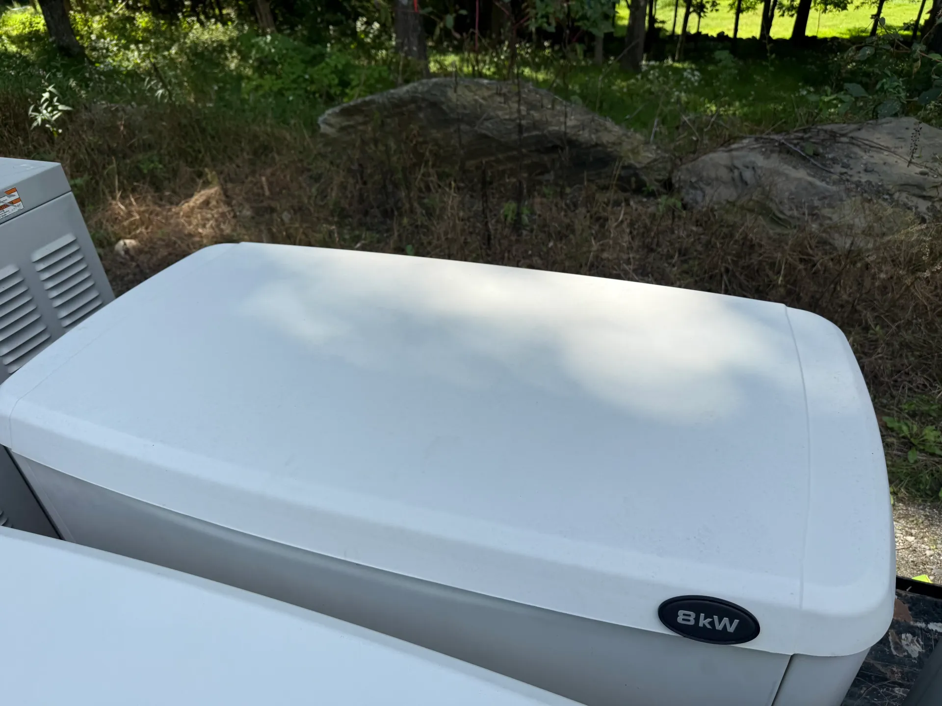 White standby generator with a visible 8 kW badge